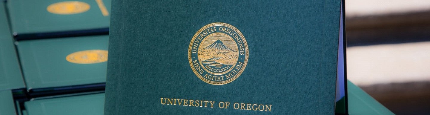 University of Oregon diploma covers lined up on a table